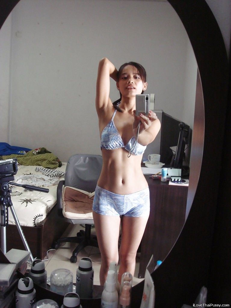Худенькая азиатка фотографируется обнаженной перед зеркалом