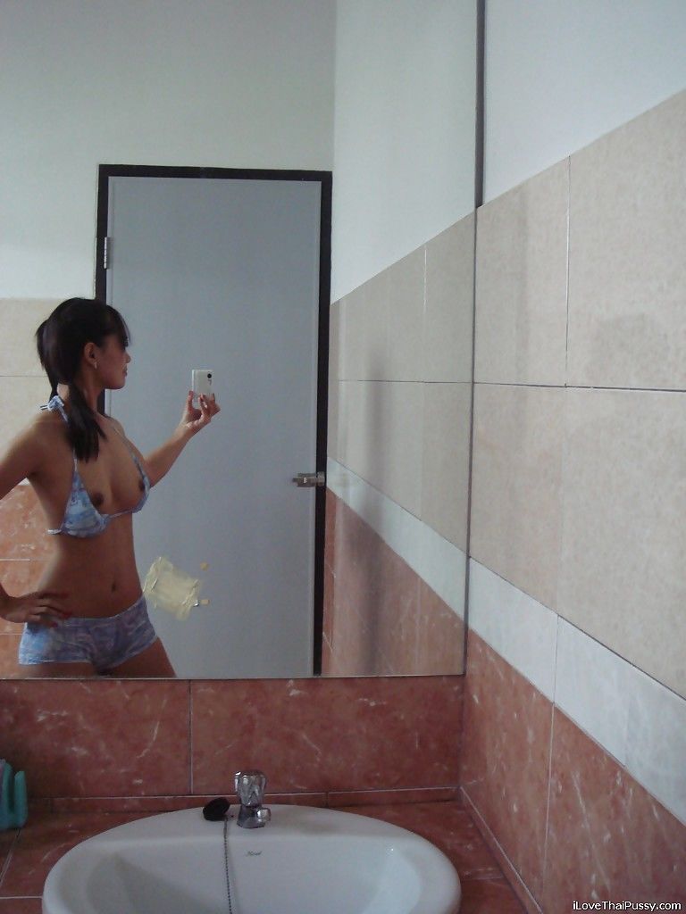 Худенькая азиатка фотографируется обнаженной перед зеркалом