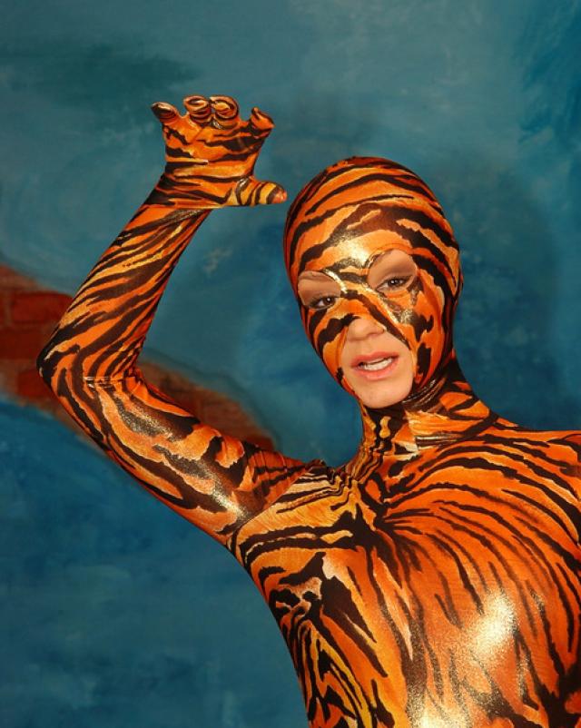 Красивая гимнастка снимает с себя тигровый спандекс